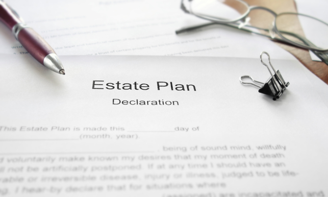 An Estate Plan document on a desk with glasses and pen
